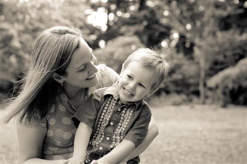 Mother holding boy in her lap, both smiling